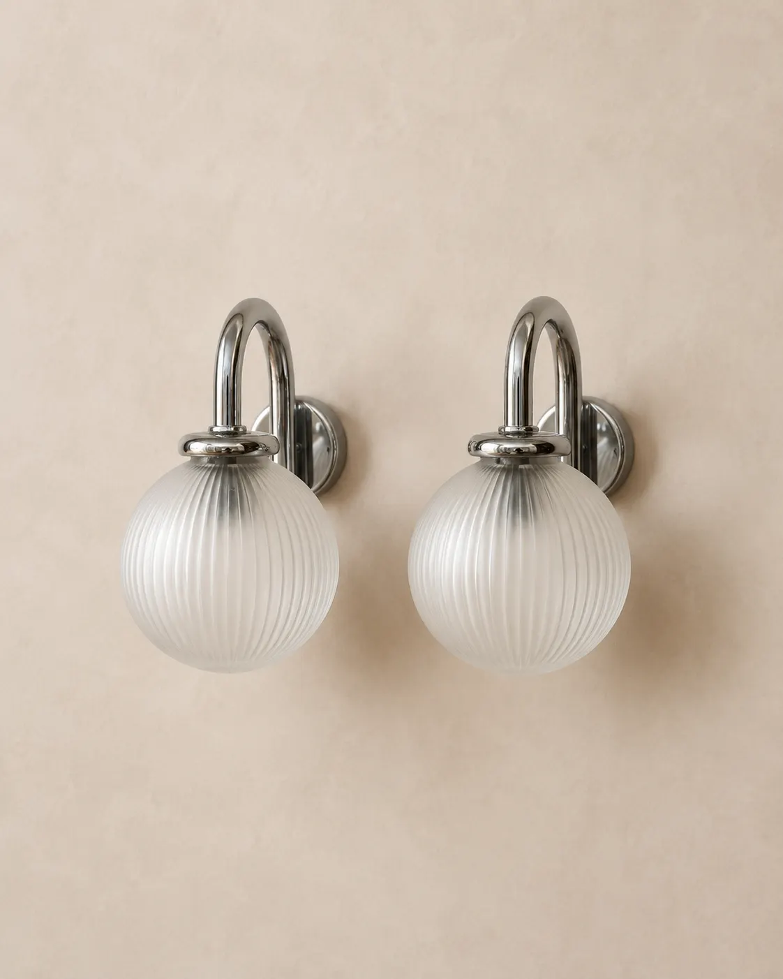 Vintage chrome and ribbed frosted glass globe bathroom wall sconces.
